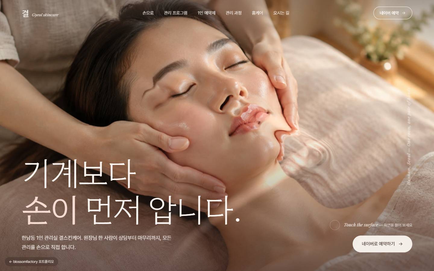 원장님의 두 손이 고객의 얼굴을 감싼 사진 위 "기계보다 손이 먼저 압니다" 문구, 턱선 아래로 손이 지나간 자리에 번지는 물결 효과와 Touch the surface 안내